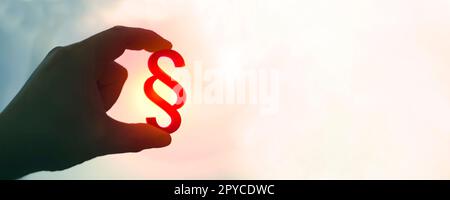 La main tient le symbole de paragraphe au soleil. Image panoramique avec espace de copie. Banque D'Images