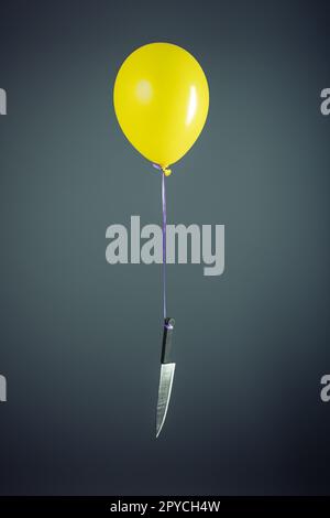 Grand couteau attaché à un ballon jaune Banque D'Images