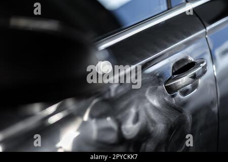 Voiture moderne dans un atelier de détail sur lequel on travaille, décontaminé, ciré, poli, fini à la perfection Banque D'Images