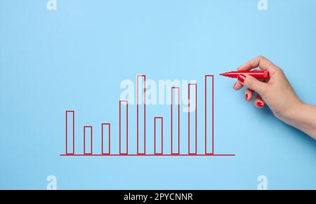 Graphique avec des indicateurs de croissance et une main femelle avec un marqueur sur fond bleu. Le concept de ventes réussies dans les affaires, l'inflation et la hausse des prix Banque D'Images