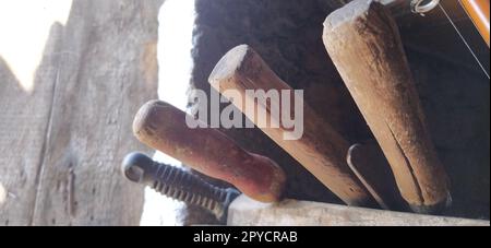 vieux outils agricoles aux murs de la maison. poignées d'outils de grange Banque D'Images