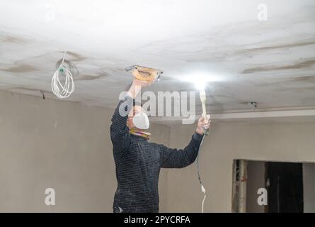 ponçage manuel du plafond en plaques de plâtre avec une truelle Banque D'Images