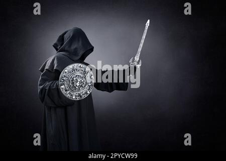 Chevalier foncé avec épée et bouclier sur fond sombre et brumeux Banque D'Images