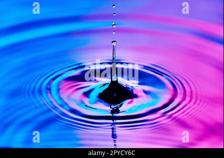 une goutte d'eau tombant dans l'eau et créant des vagues Banque D'Images