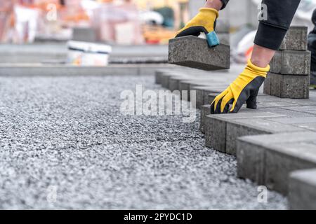 pose de pavés à interverrouillage pendant la construction de trottoirs et de routes. copier l'espace Banque D'Images