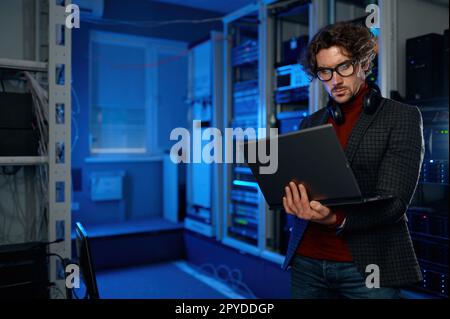 Ingénieur réseau utilisant une tablette numérique dans la salle des serveurs pendant les travaux de maintenance Banque D'Images