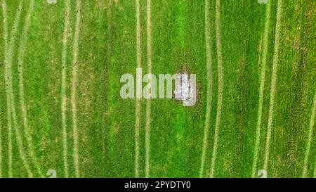 Vue de dessus sur les champs avec chenilles de pneus de tracteurs et de machines agricoles. Banque D'Images