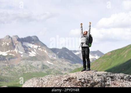 Randonneur excité célébrant les vacances levant les bras dans la nature Banque D'Images