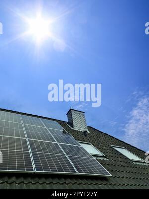 Panneaux solaires produisant de l'énergie propre sur le toit d'une maison résidentielle Banque D'Images