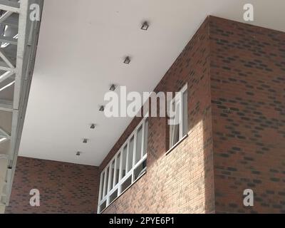 Extérieur de la nouvelle école. Nouvelles fenêtres blanches en plastique. Brun à la mode - brique de parement rouge. Arche métallique avec auvent. Plafonnier. Entrée de l'école. Serbie, Sremska Mitrovica. Banque D'Images