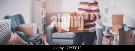 Femme portant une boîte en carton dans ses mains Banque D'Images