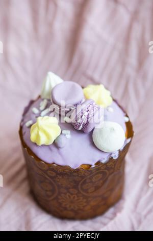 Un paska traditionnel décoré de chocolat suisse blanc et de meringue se dresse sur une nappe de lavande. Vacances de Pâques. Banque D'Images