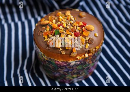 Un gâteau de Pâques décoré de fruits confits est posé sur un tablier bleu rayé. Concept de vacances religieuses de Pâques. Banque D'Images