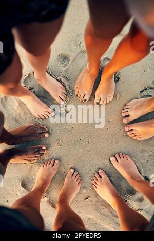 Paix, amour et pieds de sable. les jeunes traînaient à la plage. Banque D'Images