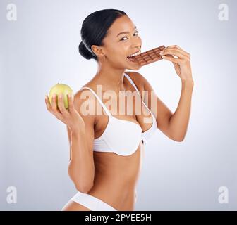 Femme noire, manger du chocolat et la nutrition santé en fond de studio pour des soins de la peau sains, beauté bien-être et portrait modèle. Femme africaine, régime de perte de poids et peau lush dermatologie Headshot Banque D'Images