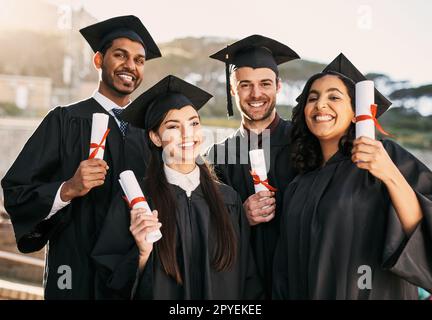 Des carrières réussies - ici, nous venons. Portrait d'un groupe d'étudiants célébrant avec leurs diplômes le jour de la remise des diplômes. Banque D'Images