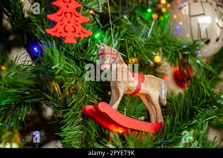 Cheval à bascule sur l'arbre de noël avec des boules et des lumières. Banque D'Images