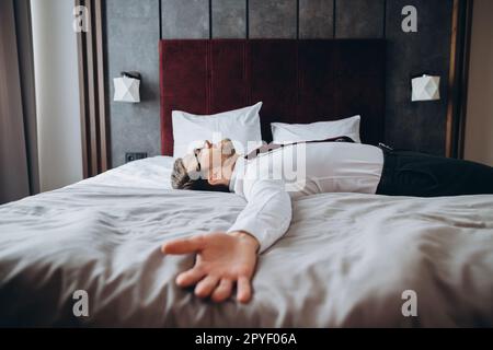 Homme d'affaires épuisé reposant sur le lit après un long vol d'air, décalage horaire. Banque D'Images