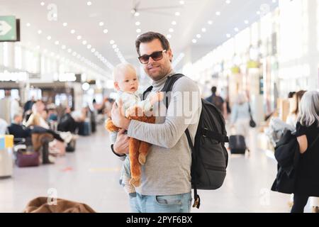 Père voyageant avec son enfant, tenant son bébé garçon au terminal de l'aéroport attendant de monter à bord d'un avion. Concept de voyage avec enfants. Banque D'Images