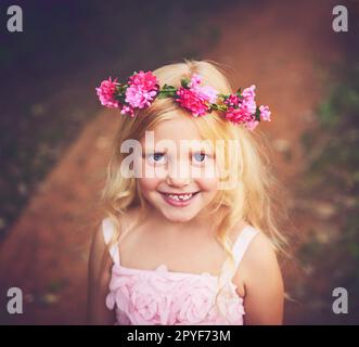 Bonheur de l'enfance. une petite fille heureuse regardant l'appareil photo et souriant en se tenant au milieu d'une route de terre. Banque D'Images