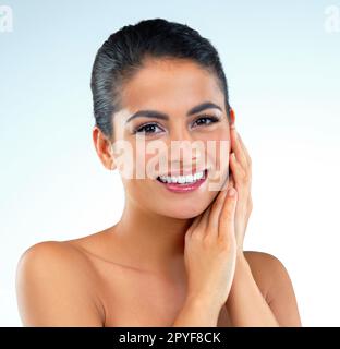 Mignon mais captivant. Photo studio d'une belle jeune femme posant sur un fond bleu. Banque D'Images