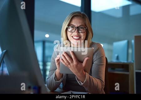 Ce bureau est essentiellement ma deuxième maison. Portrait rogné d'une femme d'affaires travaillant sur une tablette numérique dans son bureau tard dans la nuit. Banque D'Images