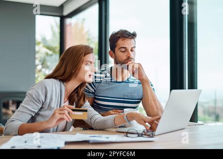 HES lui donnant un peu de réflexion. un jeune couple qui travaille sur le budget de son ménage et qui paie ses factures en ligne. Banque D'Images