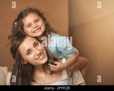 Je veux ma mère. une mère heureuse et une fille qui s'amusent tandis que la mère porte la fille sur son dos. Banque D'Images