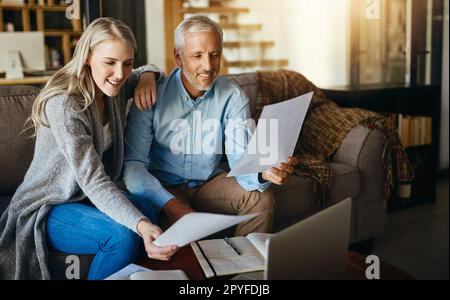 J'ai l'air d'avoir suffisamment économisé pour passer de belles vacances. un couple qui passe par leurs documents ensemble à la maison. Banque D'Images