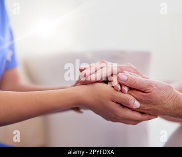 Je vous promets que ça va s'améliorer. une infirmière tient les mains d'un femme âgé dans le confort. Banque D'Images