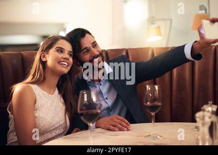 Prenez toujours le temps de faire un selfie. un jeune couple qui prend un selfie tout en un temps romantique. Banque D'Images