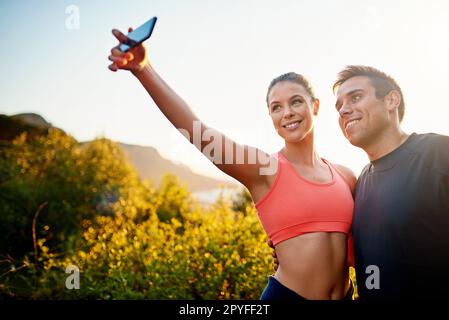 Un moment de remise en forme avec ma personne préférée. un jeune couple sportif qui prend un selfie pendant une course ensemble. Banque D'Images