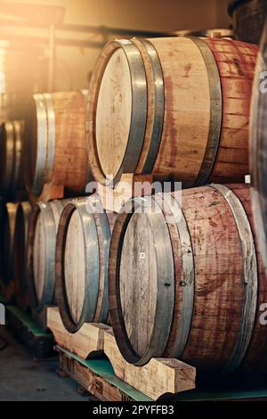 De ceux qui savent le mieux. fûts de vin empilés les uns sur les autres dans une distillerie de vin. Banque D'Images