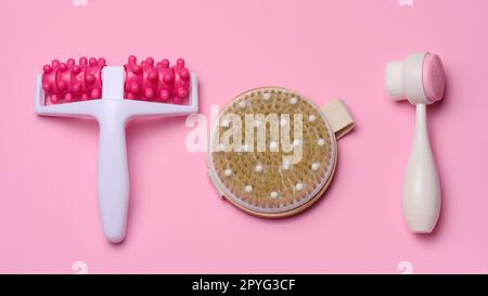 Brosse ronde en bois, masseur pour le corps en plastique et brosse pour le visage sur fond bleu, vue du dessus. Soins du corps Banque D'Images