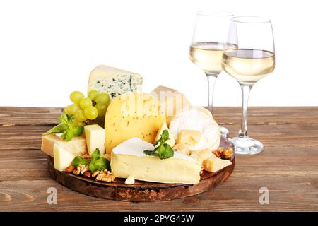 Différents types de fromages savoureux et de verres avec vin sur table sur fond blanc Banque D'Images