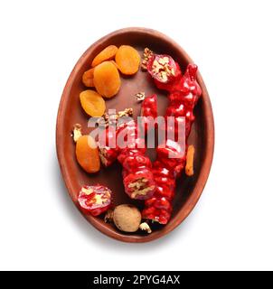 Assiette avec churchkhèle savoureux et abricots séchés sur fond blanc Banque D'Images