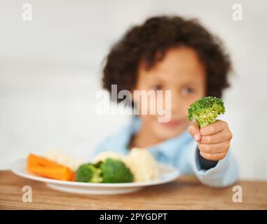 Je n'aime pas les légumes. Un petit garçon très mécontent d'avoir à manger des légumes. Banque D'Images