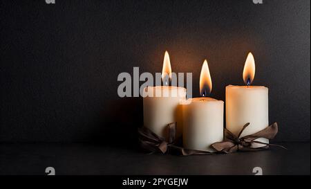 Trois bougies de cire brûlantes sur fond de sol noir et de mur sombre Banque D'Images