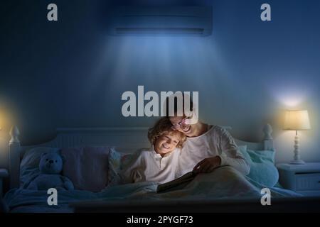 Climatisation dans la chambre. Climatisation réglable dans la chambre des enfants. Mère et enfant au lit sous la brise d'air frais. Température confortable pour un sommeil sain Banque D'Images