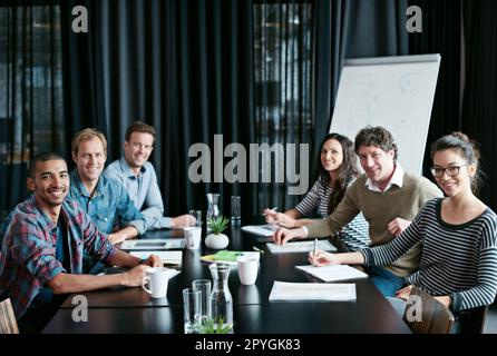 La réussite commence dans cette salle de réunion. Portrait d'un groupe diversifié de professionnels assis à une table dans une salle de conférence. Banque D'Images