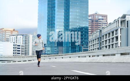 Il possède cette route. un jeune homme qui fait du jogging dans des rues de ville vides. Banque D'Images