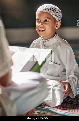 Enfant musulman, mosquée et coran avec enseignant pour l'apprentissage spirituel, le développement ou la croissance sur tapis. Enseignement islamique, homme et garçon pour le culte sacré, livre ou lecture pour la foi, l'islam ou l'étude au Qatar Banque D'Images