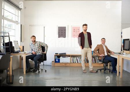 Travailler en équipe permet de faire les choses. Espace de bureau ouvert avec 3 professionnels de la création qui regardent la caméra. Banque D'Images