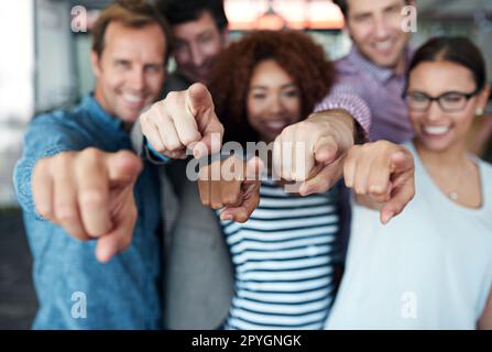 Nous vous avons fait découvrir nos sites. Portrait d'un groupe de collègues de bureau pointant vers l'appareil photo. Banque D'Images