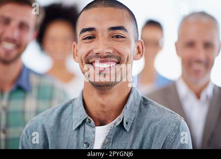 Portrait de confiance professionnelle. Gros plan sur un homme d'affaires souriant avec des collègues en arrière-plan. Banque D'Images