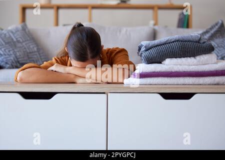 Femme, stress ou blanchisserie dans le salon de la maison, appartement ou hôtel pour le ménage, le nettoyage de la santé ou l'entretien de l'hygiène. Burnout, anxiété ou femme de ménage fatiguée et vêtements, tissu ou linge plié sur le canapé Banque D'Images