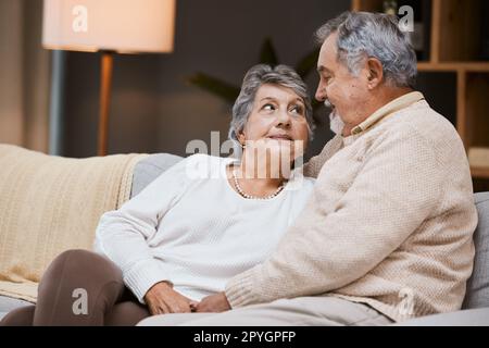 Amour, canapé et couple senior parlant, mariage et lien pour la relation, la retraite et la romance. Romantique, homme âgé et femme mature dans le salon, conversation et détente sur les vacances de week-end. Banque D'Images