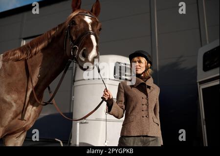 Jeune adulte rider souriant femme qui a le nez d'un cheval Banque D'Images