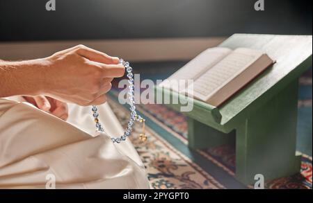 Coran, perles ou mains priant dans la religion islamique ou musulmane Allah pour la paix spirituelle ou la liberté dans la mosquée au Qatar. Musulman prier, lire ou personne agenouillée sur le tapis dans le temple sacré pour louer Dieu Banque D'Images