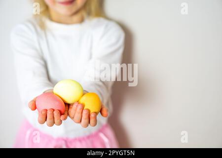 Enfants mains tenant des oeufs de Pâques colorés. Joyeuses Pâques. Préparation pour Pâques et printemps. Banque D'Images